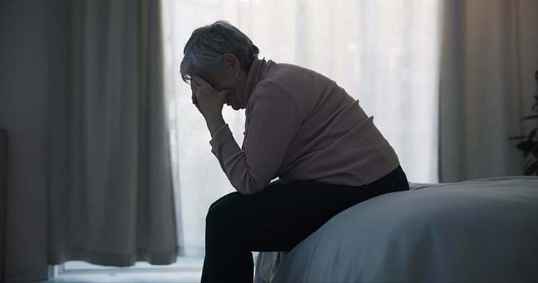 Exhausted woman on the edge of her bed