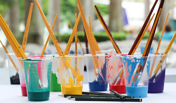 cups of paint with brushes