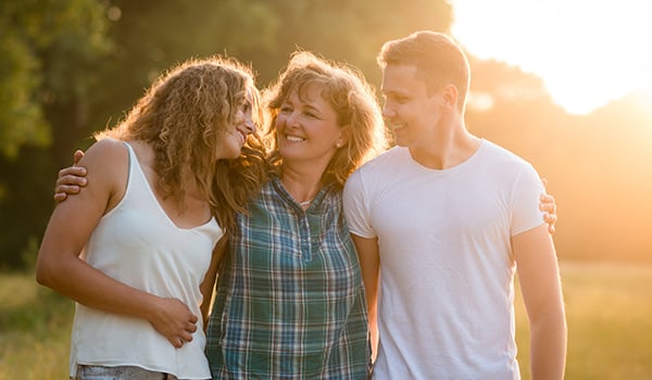 mom hugging two teenage children