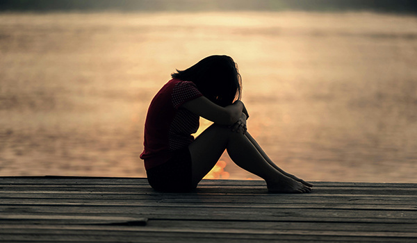 woman hiding face on dock